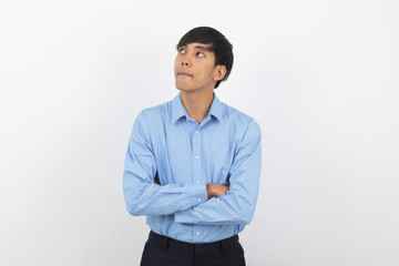 Young handsome asian man thinking an idea while looking up with arms crossed isolated on white background.