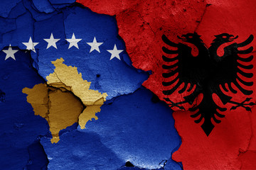 flags of Kosovo and Albania painted on cracked wall