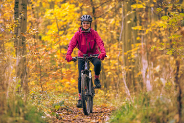 nice senior woman riding her mountainbike on the autumnal forest trails near Stuttgart, beautiful...