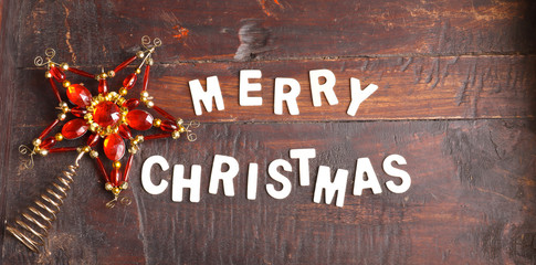 Fototapeta na wymiar Christmas Star and words Merry Christmas isolated on old wooden background. Flat lay, top view
