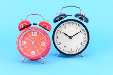 Alarm clock on blue background. Selective focus.