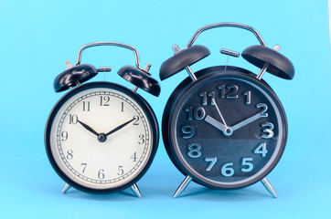 Alarm clock on blue background. Selective focus.