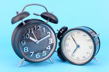 Alarm clock on blue background. Selective focus.