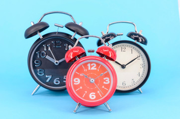 Alarm clock on blue background. Selective focus.