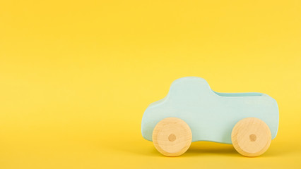 Yellow background with children's blue toy car and copyspace