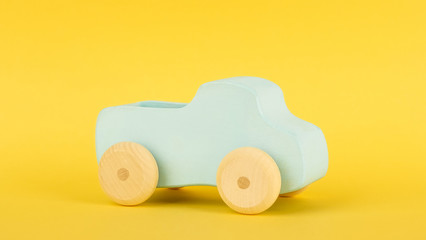 Children's blue toy car on a yellow background minimal style isolated