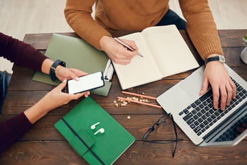 Above view background of young businessman or college student using laptop sitting at wooden desk while working or studying, copy space