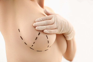 Female hand in gloves holding breast closeup