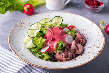 Delicious meat salad with roast beef, vegetables and cranberry sauce. Tasty meat salad