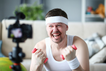 Fototapeta na wymiar Male vlogger holds dumbbells in his