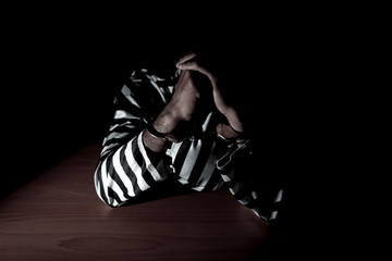 The suspect wear prisoner cloths was arrested at the investigation, interview to find out the truth, the thief was caught by the police come to the dark room,Thailand people,Knife in hand