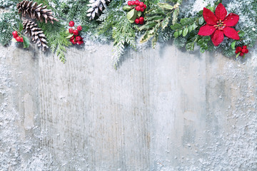 Christmas and New Year background with fir branches and snowfall on wooden white board