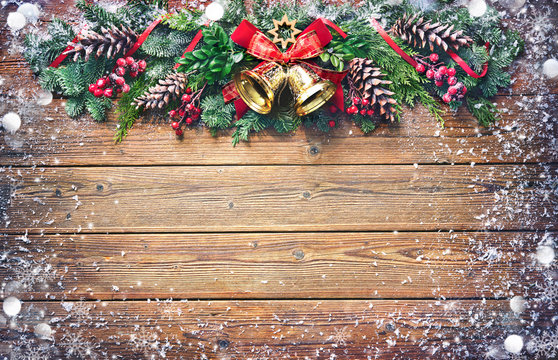 Christmas background with bells, fir tree and decoration on dark wooden