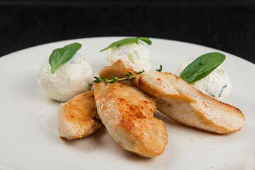 Grilled chicken breast with mozzarella cheese decorated with basil. Concept for a healthy meal.