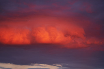 Naklejka na ściany i meble evening clouds lit by the setting sun. background.