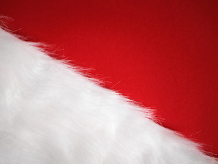 Red and white diagonal Christmas background, in Santa colours with faux fur and copy space