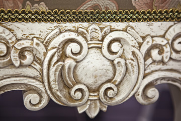 carving element. furniture in classic style. white color wood with gold trim. patina. carving. small depth of field. luxury furniture. use as background.