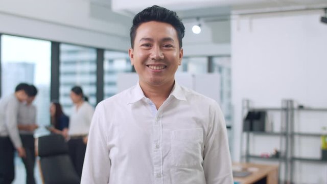 Portrait of successful handsome executive businessman smart casual wear looking at camera and smiling, arms crossed in modern office workplace. Young Asia guy standing in contemporary meeting room.