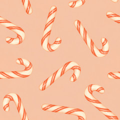 Obraz premium Red and white striped candy canes on a pink background. Christmas seamless pattern with candy canes