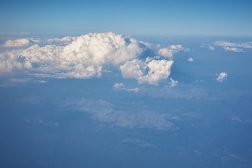 Fototapeta na wymiar Blue cloudy sky, view from the airplane window