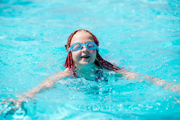Naklejka premium teenage girl in outdoor pool with safety glasses