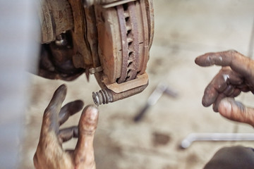 Closeup of a car mechanic's hand. Car brake replacing new caliper pin. car repair, suspension...