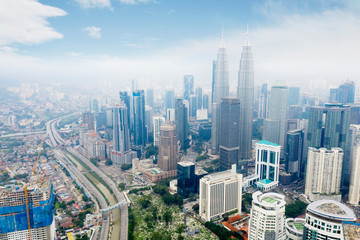 KUALA LUMPUR - Malaysia. November 12, 2019: Aerial drone view of Kuala Lumpur CBD area with Petronas Twin Towers and near Highway shot at midday over blue sky