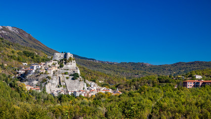 Naklejka premium A view of the ancient village of Cerro al Volturno, surrounded by green woods and mountains. The Pandone castle stands on top of the hill, on a rock spur. Isernia, Molise, Italy.