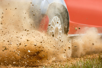 Gravel splashing from rally race car drift on track. - Powered by Adobe