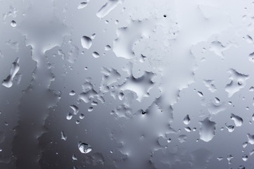 glass in the window covered with wet melting snow, close-up, macro photo