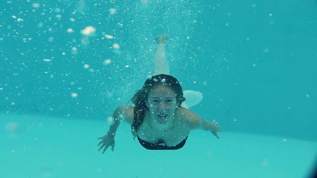 female model diving under water in pool