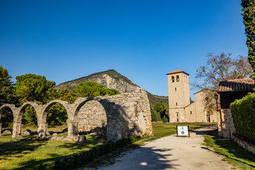 Fototapeta na wymiar San Vincenzo al Volturno, a Benedictine monastery in Castel San Vincenzo and Rocchetta a Volturno. The new abbey. The remains of walls of an ancient building, with a series of stone arches.