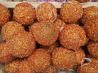 Sparkling golden Christmas balls background with selective focus. Pile of colorful Christmas balls. Christmas tree decoration balls. New year backdrop. 
