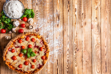 Pizza with vegetables on wooden background