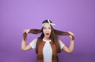 Astonished young lady holds her hair in her hands.