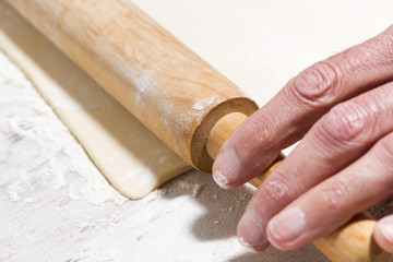 the process of rolling dough. hands and rolling pin, selective focus