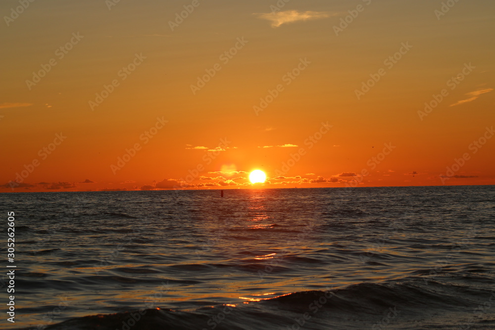 Wall mural the sun setting over the ocean