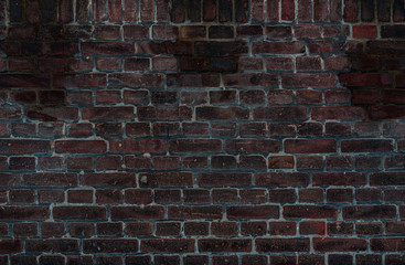 Texture of an old brown brick wall with wet spots
