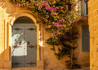 Fototapeta na wymiar beatiful windows and doors in the street of ancient mdina town, malta