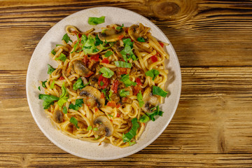 Pasta with mushrooms and tomato sauce on wooden table. Top view