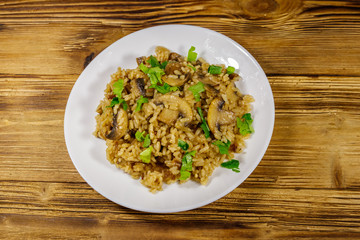 Tasty risotto with mushrooms on wooden table. Top view