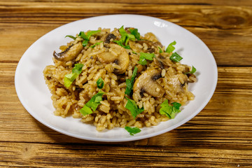Tasty risotto with mushrooms on wooden table