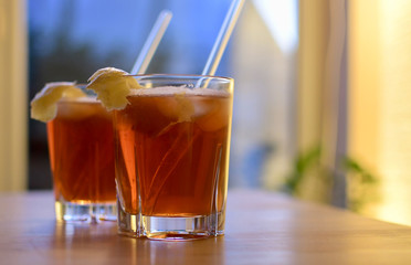 two glasses of orange aperol drinks with fruit deko on a wooden table