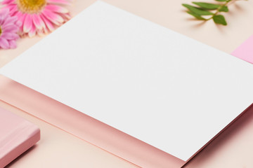 white paper mockup on peach background flower petal floral feminine pastel rose pink planner book envelope paper