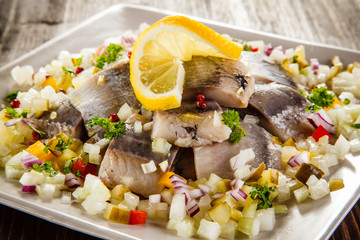 Marinated herrings on wooden table