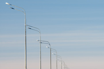 Minimalistic photo of streetlights against a blue sky in the afternoon