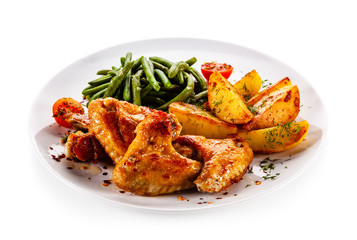 Fried chicken wings with baked potatoes and vegetable salad