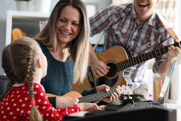 Happy family plays musical instruments on background