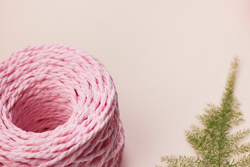 rose pink crochet yarn wool thread on peach pastel background foliage