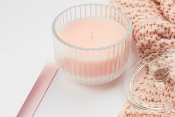 pink pastel candle in glas peach knitted wool blanket paper card